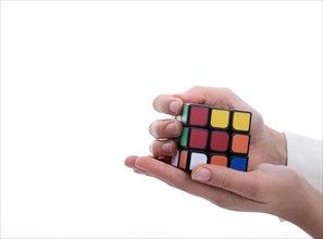 Child holding a Rubik's cube in hand on a white background