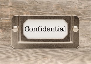 Confidential metal file label frame on wood background