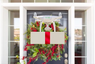 Drone delivering wrapped package with red ribbon to christmas decorated house porch