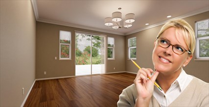 Creative woman with pencil contemplating empty room of house
