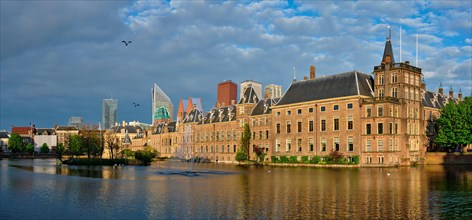 Panorama of the Binnenhof House of Parliament and the Hofvijver lake with downtown skyscrapers in background
