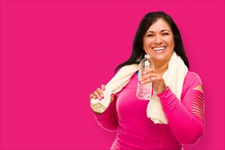 Middle aged hispanic woman in workout clothes with towel and water bottle against A magenta pink background
