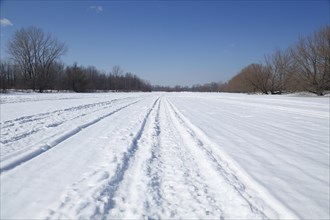 Snow vehicle tracks on a frozen river surface