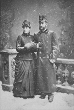 Married couple standing in the snowfall