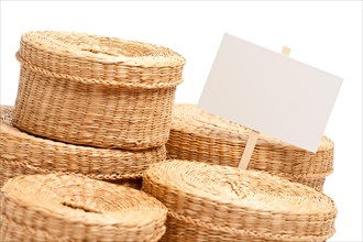 Various sized wicker baskets with blank sign isolated on white