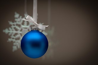 Snowflake and blue christmas ornament against dark background