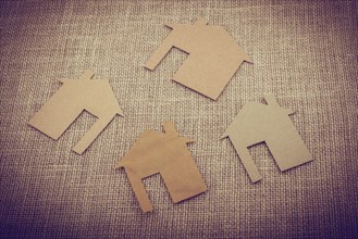 Little house shape cut out of paper on a canvas background