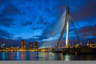 View of Erasmus Bridge Erasmusbrug and Rotterdam skyline cityscape illuminated at night