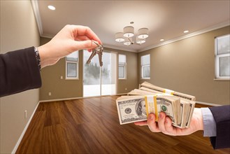 Agent handing over house keys for cash in newly remodeled room of house