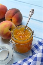 Peach jam in glass and peaches