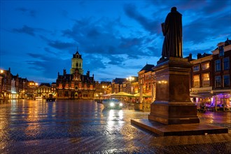 Delft City Hall and Delft Market Square Markt with Hugo de Groot Monument in the evening. Delfth