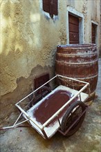 Alter Leiterwagen mit Weinfass in einer Altstadtgasse