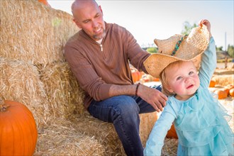 Adorable young family enjoys a day at the pumpkin patch