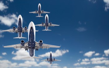 Bottom view of several passenger airplanes flying in the blue sky