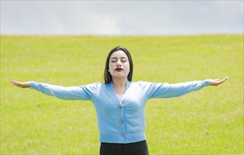 A girl spreading her arms in the field