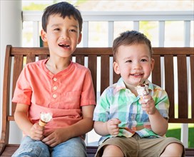 Young mixed-race chinese and caucasian brothers enjoying their ice cream cones
