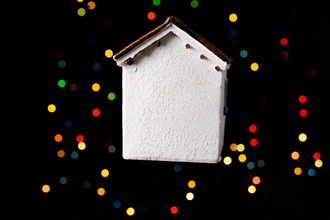 Little model house on a bokeh ligh ton a dark background