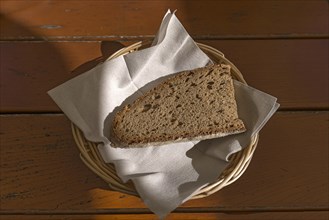 A slice of bread in a bread basket with napkin