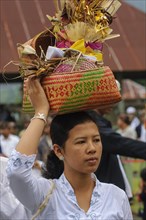 Woman carrying offerings in woven basket