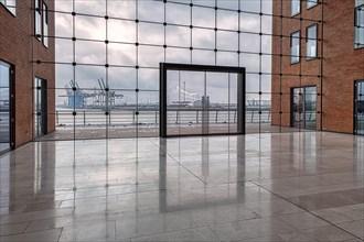 View through modern glass facade with large door onto the harbour