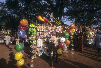 A traditional balloon vendor selling balloons during Anthimahakalan Kavu festival