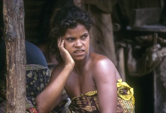 Betta Kurumba woman sitting in front of her hut