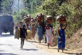 Tribal woman carrying pots on head to weekly market at Sunkarametta in Araku Valley near Visakhapatanam