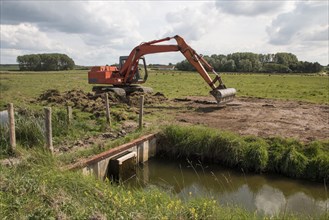Use of an excavator for maintenance work on the lock gate at Deepdale Marsh in north Norfolk