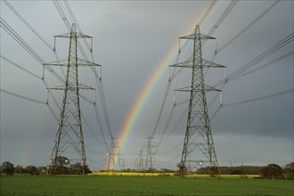 Power line pylons and rainbow