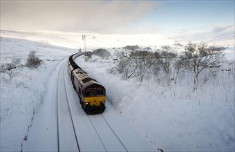 Goods train with coal load in the snow