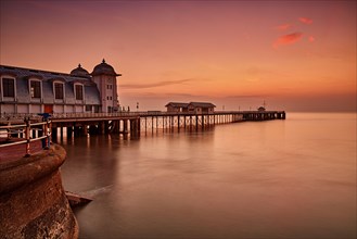 View of Victorian pier in seaside town at sunrise