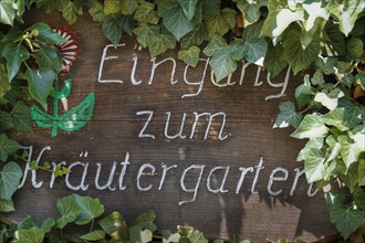 Handgeschriebenes Schild Eingang zum Kraeutergarten