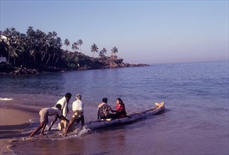 A couple enjoying a catamaran or kattumaram ride at Kovalam beach near Thiruvananthapuram