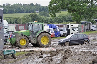 John Deere 6930 tractor pulls car from muddy car park at agricultural show cancelled due to bad weather