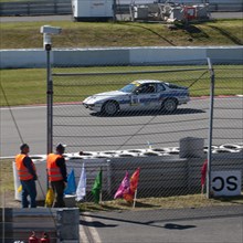 Porsche 924 on race track behind security fence