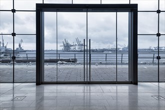 View through modern glass facade with large door onto the harbour