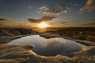 Small pool on a pebble rock at sunset