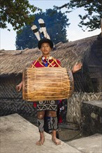 Naga tribesman in traditional dress playing drum
