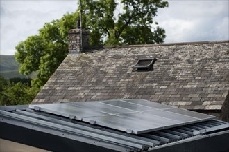 Solar energy panels attached to the garage to provide electricity for a house in a rural setting