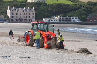 Workers with tractor on beach
