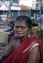 A village old woman sitting on the street of Madurai and wearing massive earrings thandatti to lengthen her ear loses