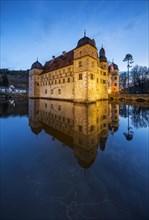 The illuminated moated castle Mitwitz in the evening