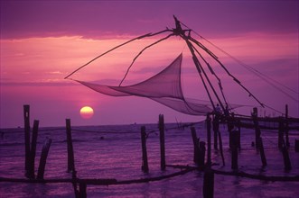 Chinese fishing nets sway away in the back drop of sunset