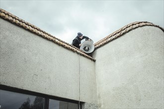 A volunteer places the air alarm siren on the roof of the House of Culture
