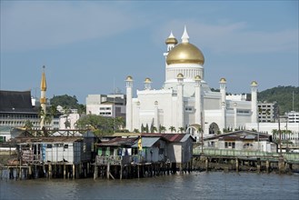 View to the mosque over huts on stilts in the river