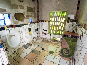 Urinal with ceramic tiles in the public toilet of the artist and architect Friedensreich Hundertwasser