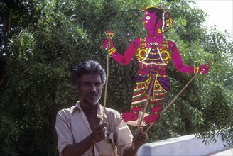 A man holding leather puppetry