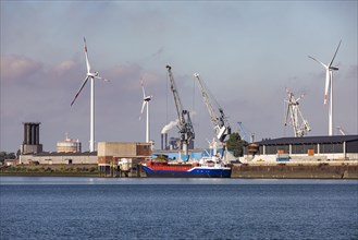 Cargo ship in front of a wind farm in the harbour