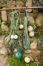 Ropes and fishing buoys stored on the wall