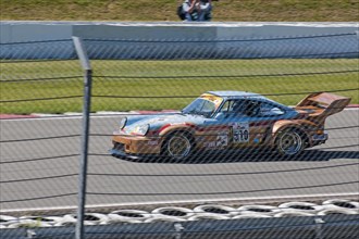 Porsche 911 RSR on race track behind safety fence
